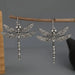 Pair of carved silver dragonfly earrings on a twig