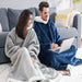 Couple on a sofa in grey and navy blanket hoodies