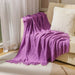 Purple diamond knit throw on a cream sofa