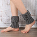 Grey knit leg warmers with buttons worn over bare ankles