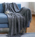 Grey diamond knit throw on a blue sofa