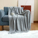 Light grey diamond knit throw on an armchair
