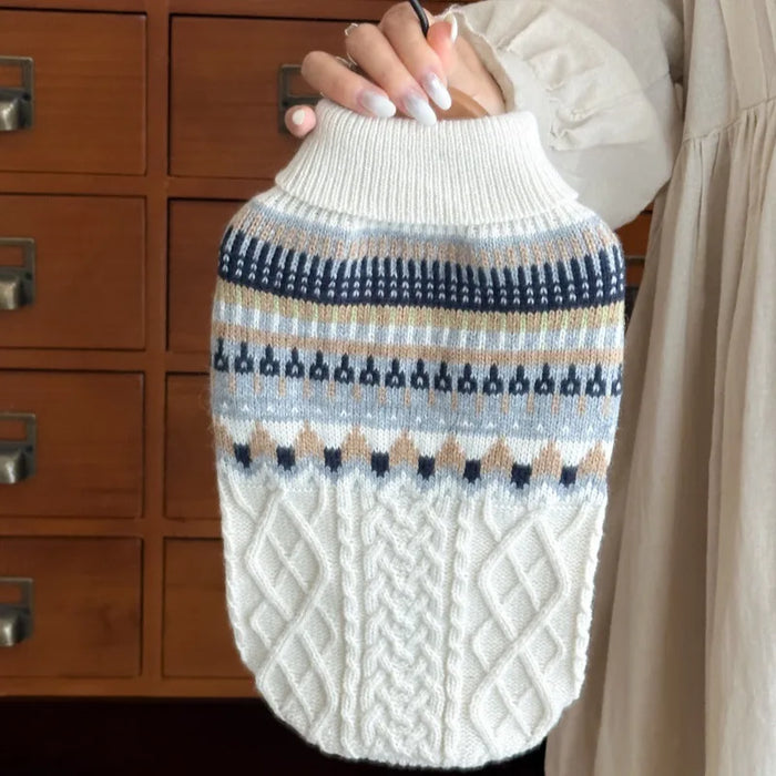 Beige cable-knit dog sweater held up by the collar