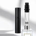 Black atomizer and its clear inner bottle beside a perfume bottle