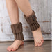 Brown knit leg warmers with buttons worn over bare ankles