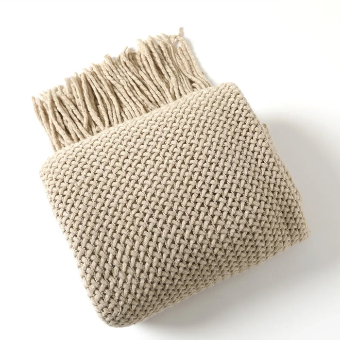 Folded khaki net knit throw blanket with tassels