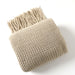 Folded khaki net knit throw blanket with tassels