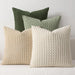 Green, sage, beige and cream textured knit cushions on a sofa