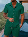 Man in a green short sleeve shirt and shorts set by the water