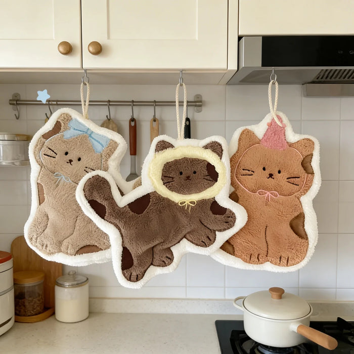Three cat hand towels hanging in a kitchen