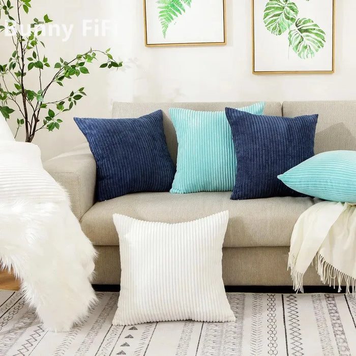 Navy, blue and white corduroy cushions on a beige sofa