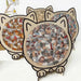 Three finished cat-shaped wooden puzzles standing together