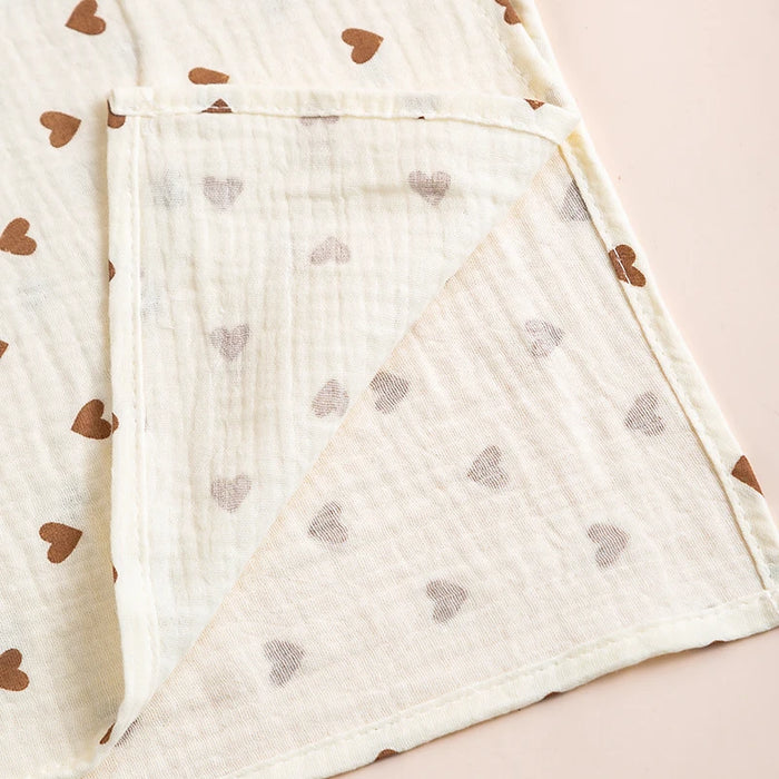 Corner of a heart print muslin blanket showing the crinkle weave