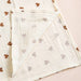 Corner of a heart print muslin blanket showing the crinkle weave