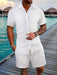 Man in a white short sleeve shirt and shorts set on a boardwalk