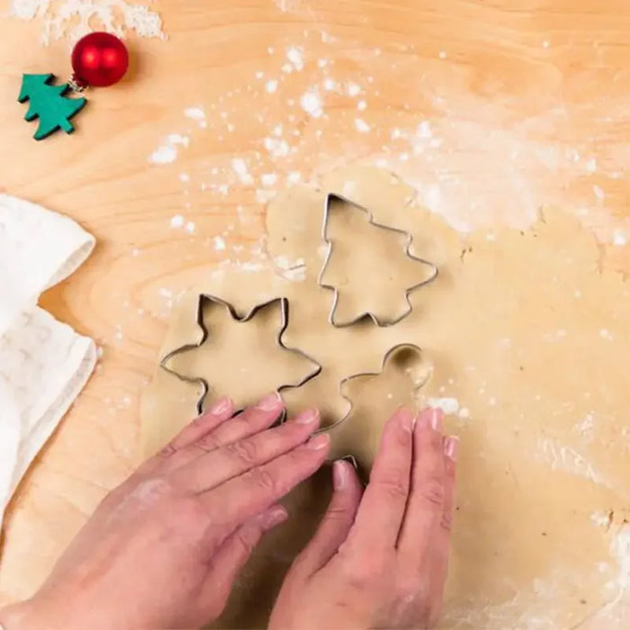 Star and tree cookie cutters on floured dough