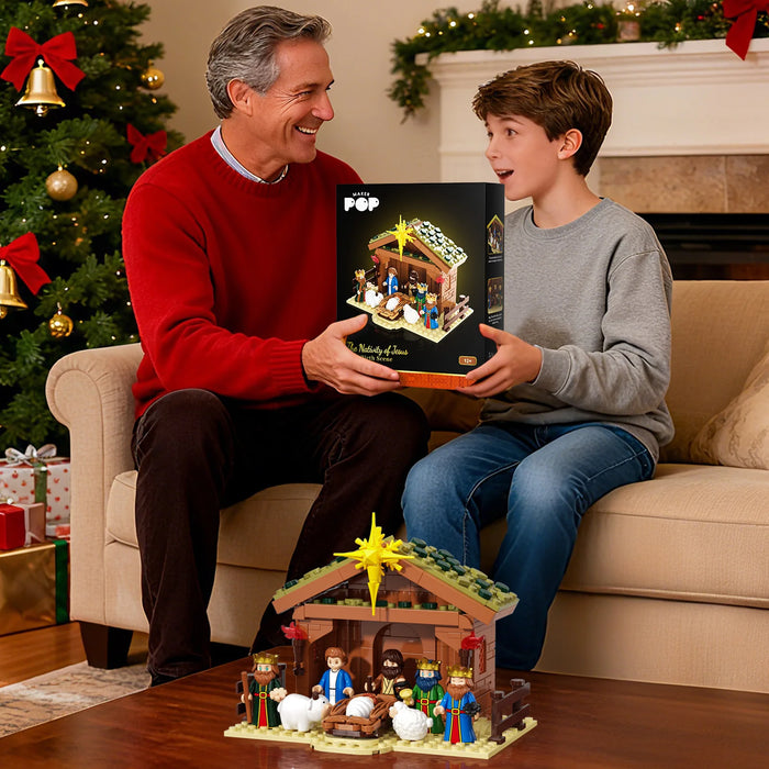 Man and boy holding the nativity scene set box by a Christmas tree