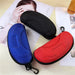 Black, blue and red sunglasses cases on a table