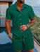 Man in a dark green short sleeve shirt and shorts set