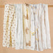 Muslin baby blankets in several prints hanging in a row