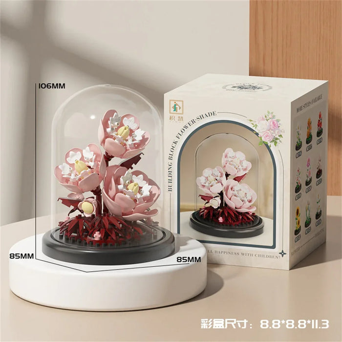 Pale pink blossom bouquet in a dome beside its colour box