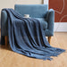 Navy bubble knit throw on a blue armchair