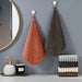 Rust and brown hand towels hanging in a bathroom