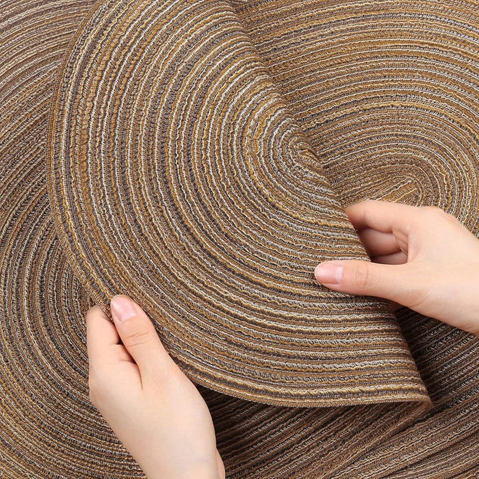 Hands bending a coffee braided placemat to show it's flexible