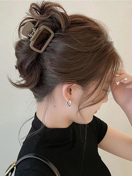 Brown square claw clip holding a low twist in dark hair