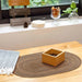 Coffee oval placemat under a wooden box on a counter