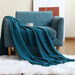 Teal navy net knit throw on a blue armchair