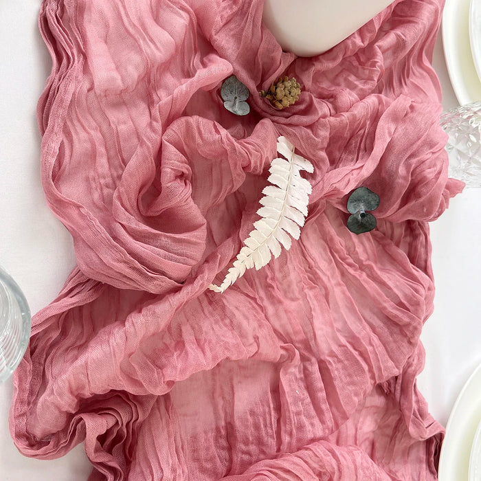Dusty pink gauze table runner with a feather