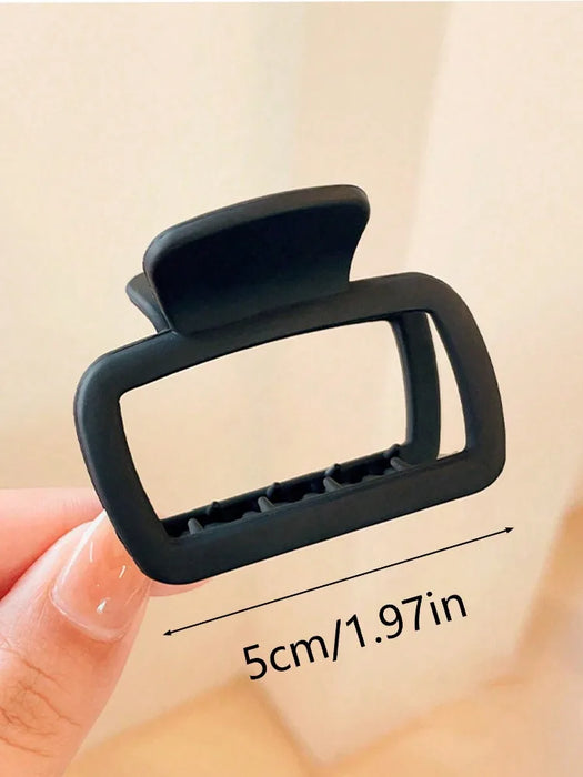 Black square claw clip in hand, about 5 cm wide