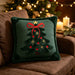 Green embroidered Christmas tree cushion on a brown sofa