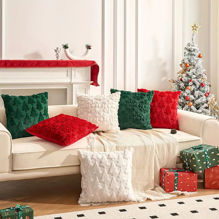 Green, red and white plush Christmas cushions on a white sofa