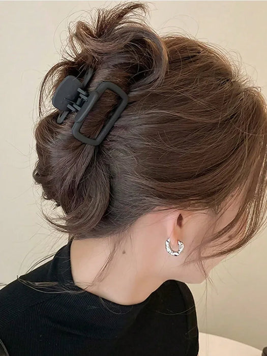 Black square claw clip holding a twisted bun