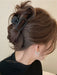 Black square claw clip holding a twisted bun