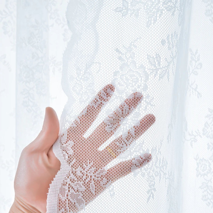 Hand behind sheer white floral lace