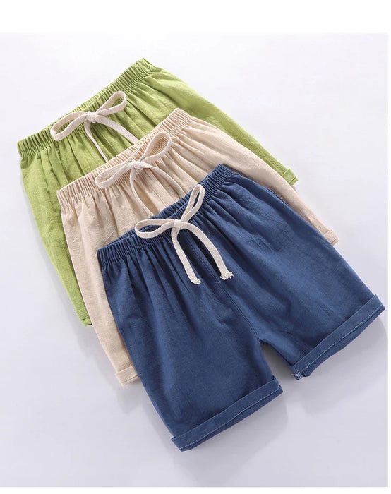Green, beige and dark blue kids' shorts stacked