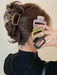 Square claw clips in brown, pink, olive and black beside a twisted updo
