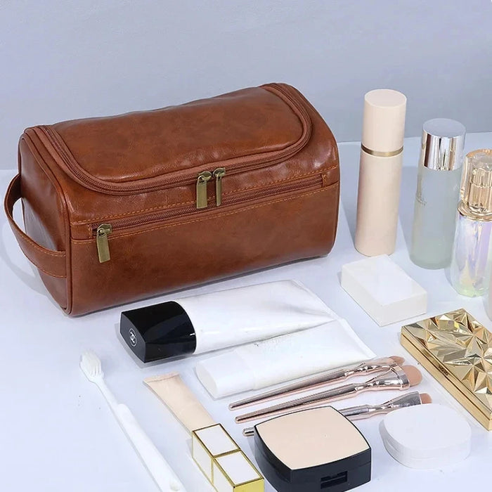 Brown toiletry bag beside skincare, makeup brushes and bottles