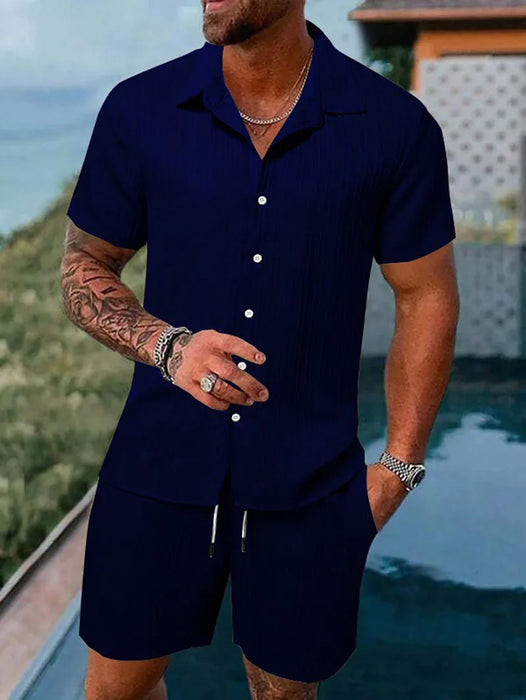 Man in a navy blue short sleeve shirt and shorts set