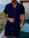 Man in a navy blue short sleeve shirt and shorts set
