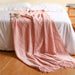 Pink cable knit throw blanket on a bed