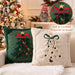 Green and beige embroidered Christmas tree cushions on a sofa
