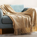 Khaki cable knit throw on a sofa