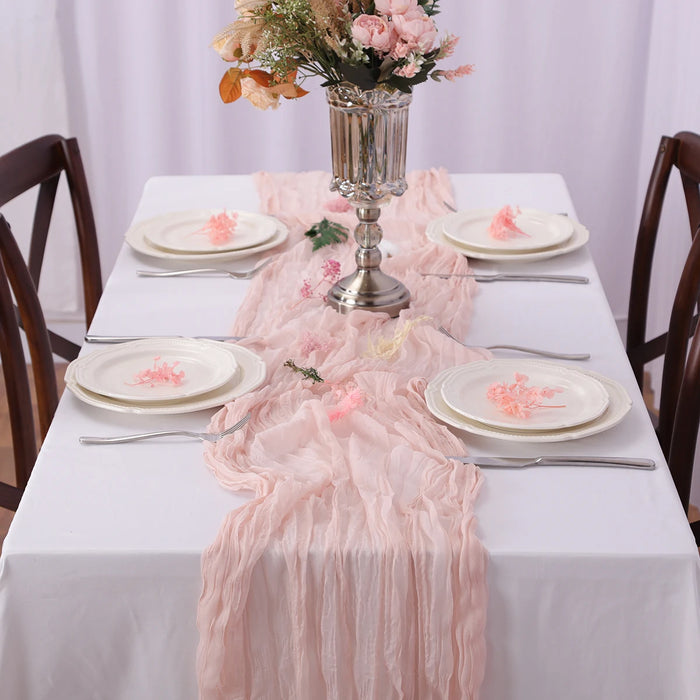 Dusty pink gauze runner on a set dinner table