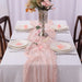 Dusty pink gauze runner on a set dinner table
