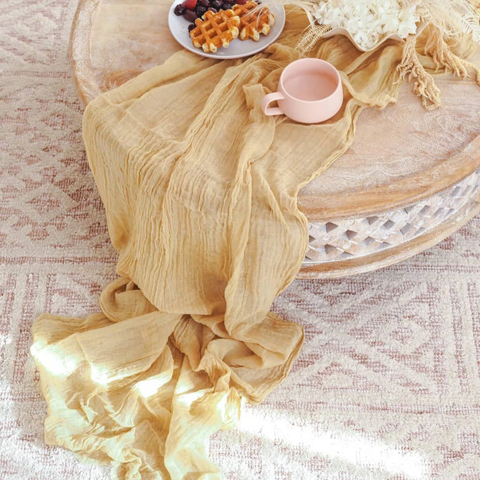 Mustard yellow gauze runner on a round table