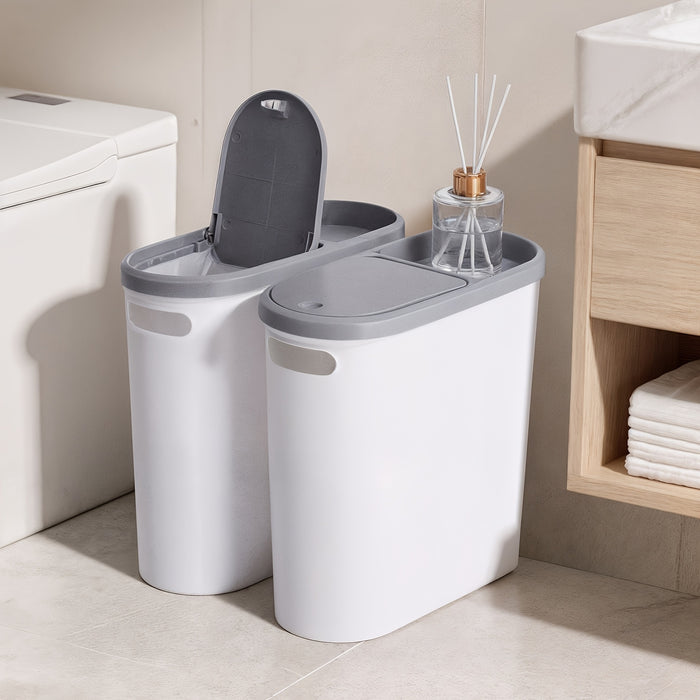 Bathroom setting with two gray trash cans and a bottle of diffuser.